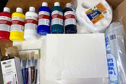 Art materials used for the painting with paitents program, including canvas, paint brushes, acryllic paints, and plastic cups