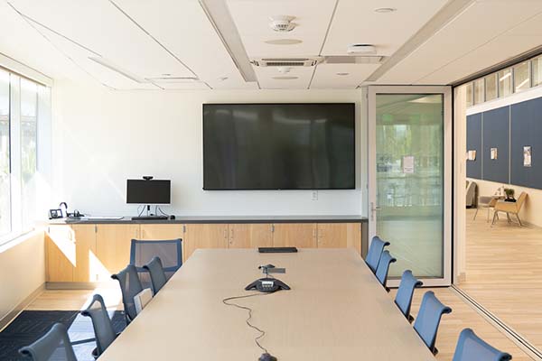 A conference room with a large display on the far wall