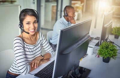 A male and female customer support employees wearing headsets