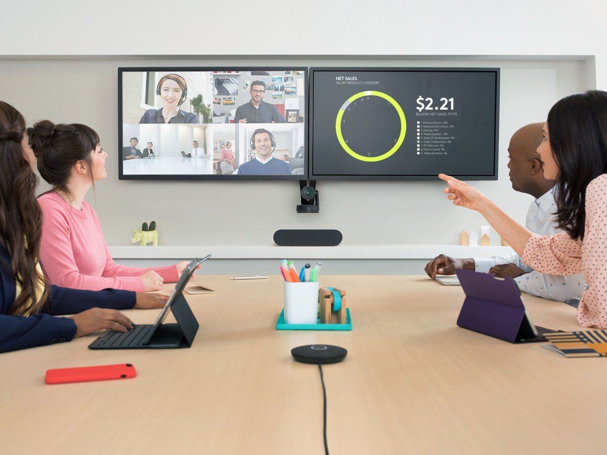 Virtual Conference with people in a meeting room watching other attendees on the screen