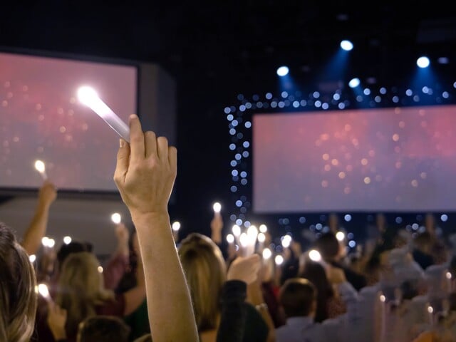 Crowd holding electric candles during a worship music performance
