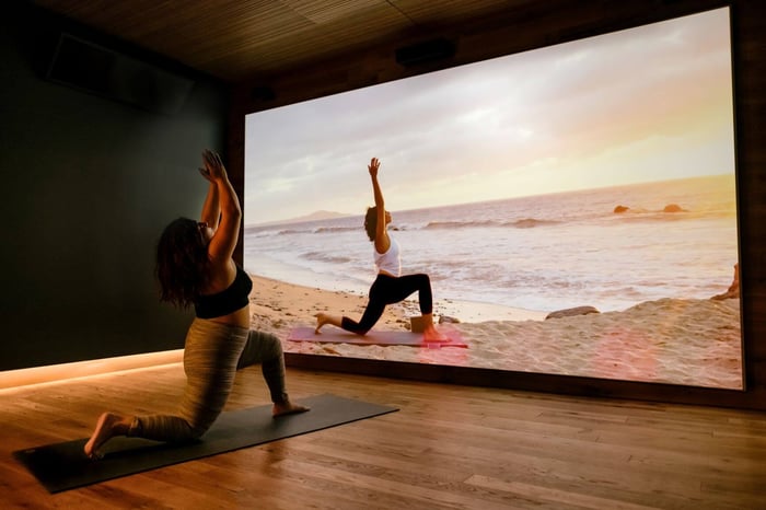 Sanctuary Studios client doing yoga in front of a projector screen