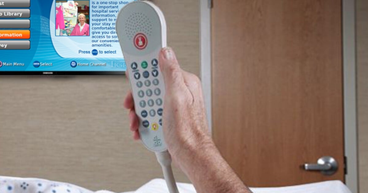 hand holding a hospital remote with a TV in the background
