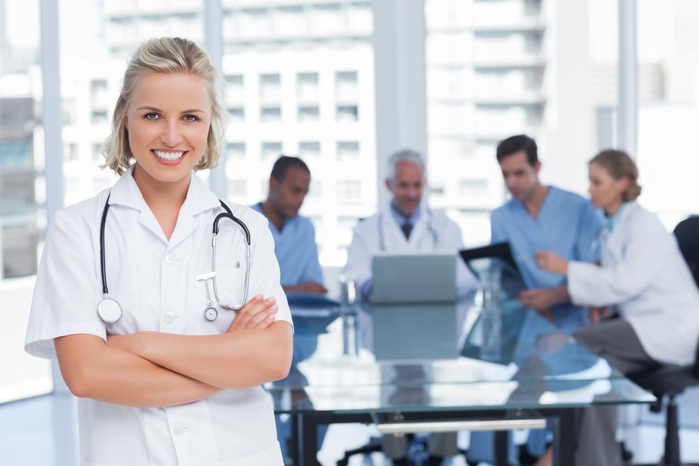 Nurse with arms crossed standing in front of her team