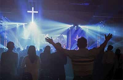 Worship service with people and lights and a large digital display