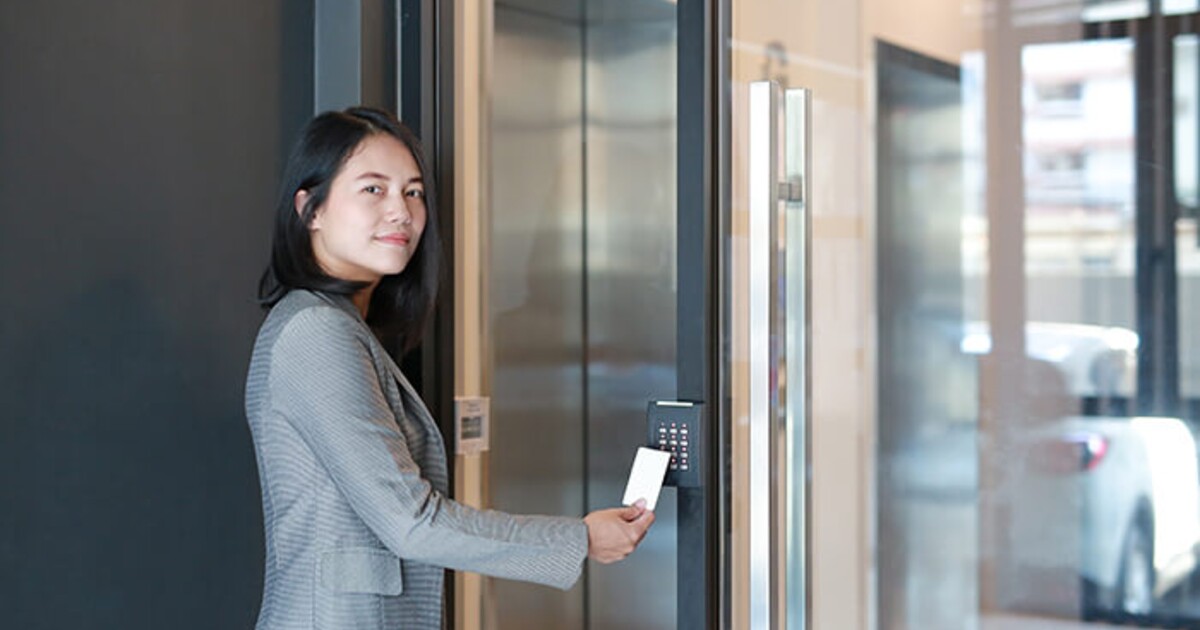 Woman swiping a keycard to get through building security Woman swiping a keycard to get through building security
